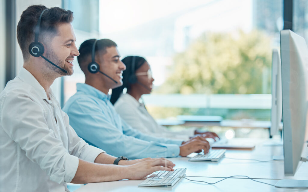 Man call center and customer service team on computer online support or workers at the office with headset Crm consultants and telemarketing agents consulting at workplace or company workspace - Serenity Sliding Door Systems