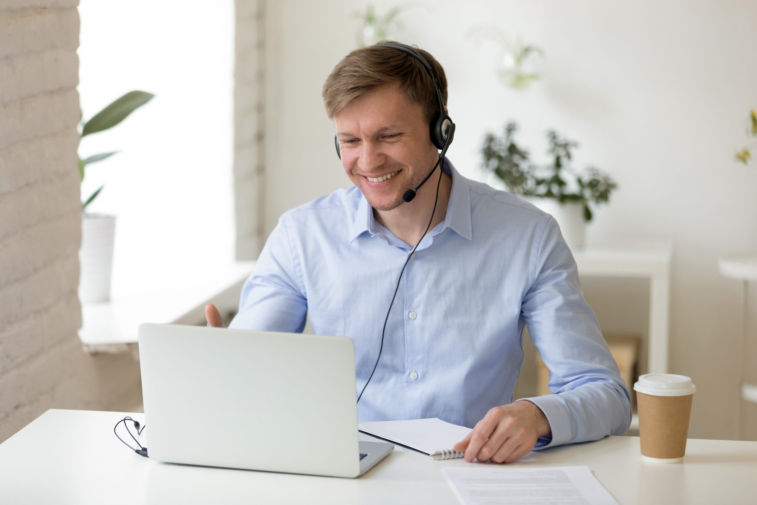 Smiling man in headphones making business video call - Serenity Sliding Door Systems